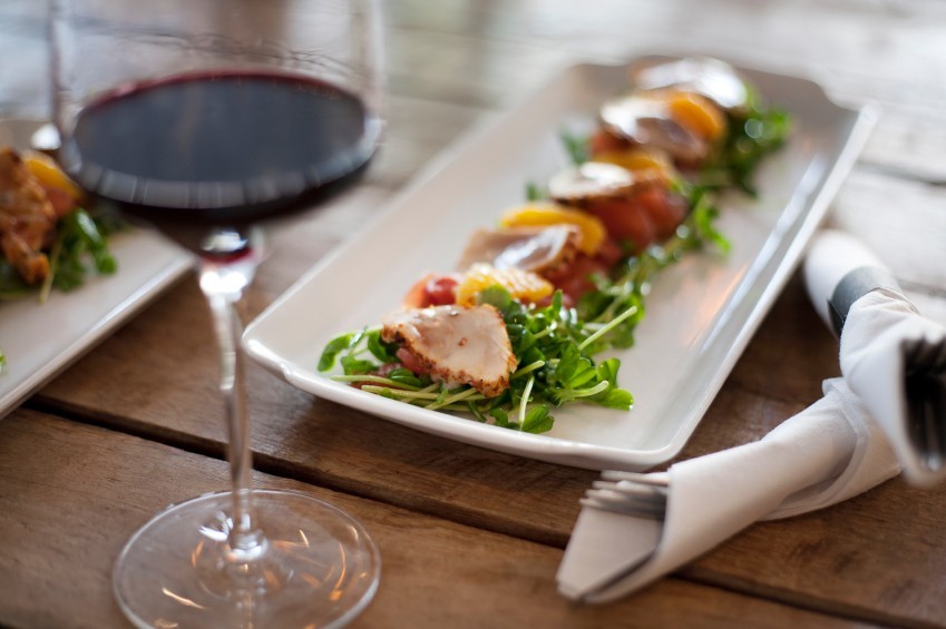 Weinglas und Platte mit edlem Fischsalat
