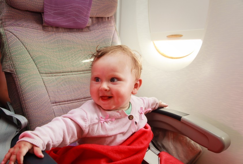 happy little girl travelling by plane