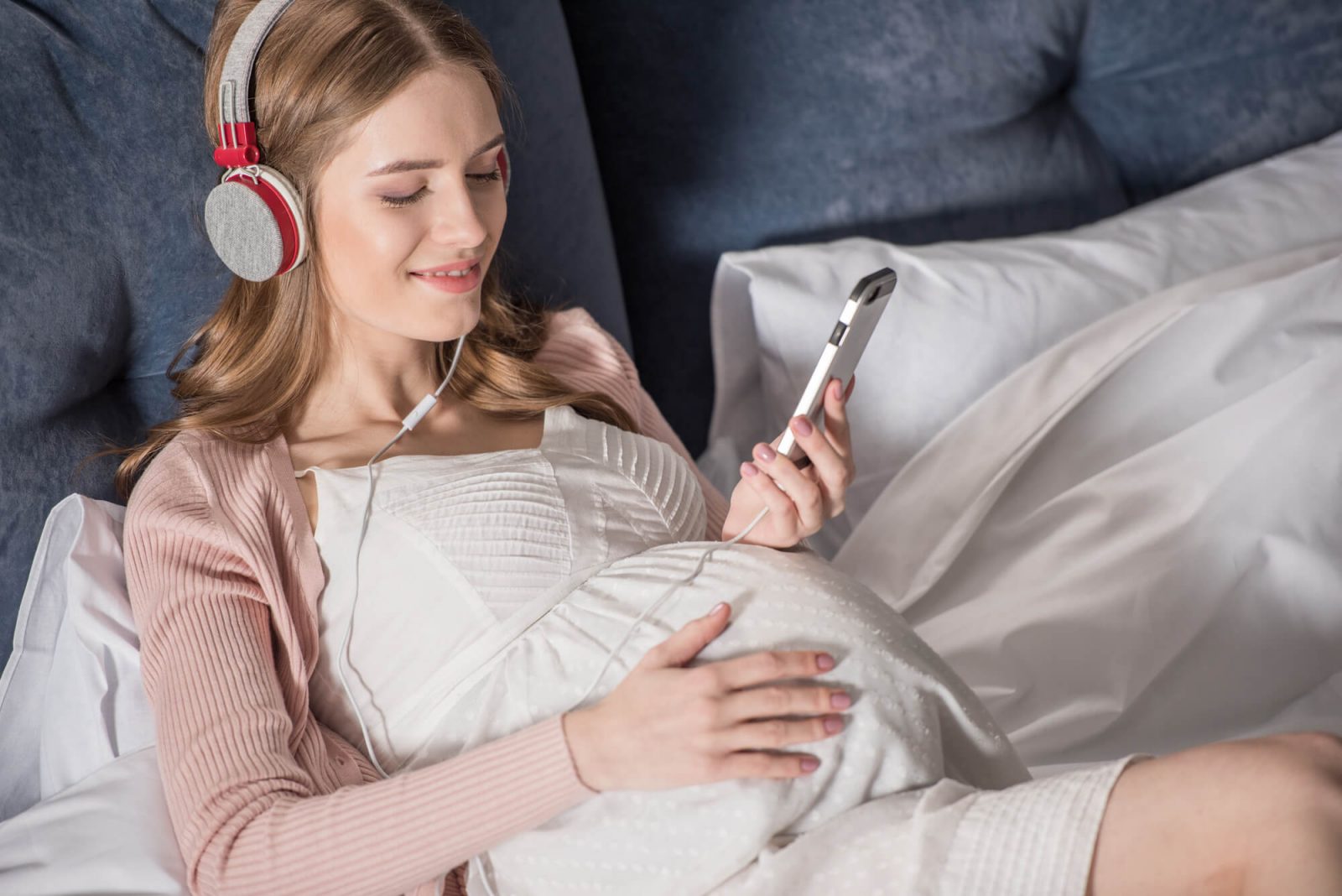 Schwangere hört Herzschlag im Smartphone